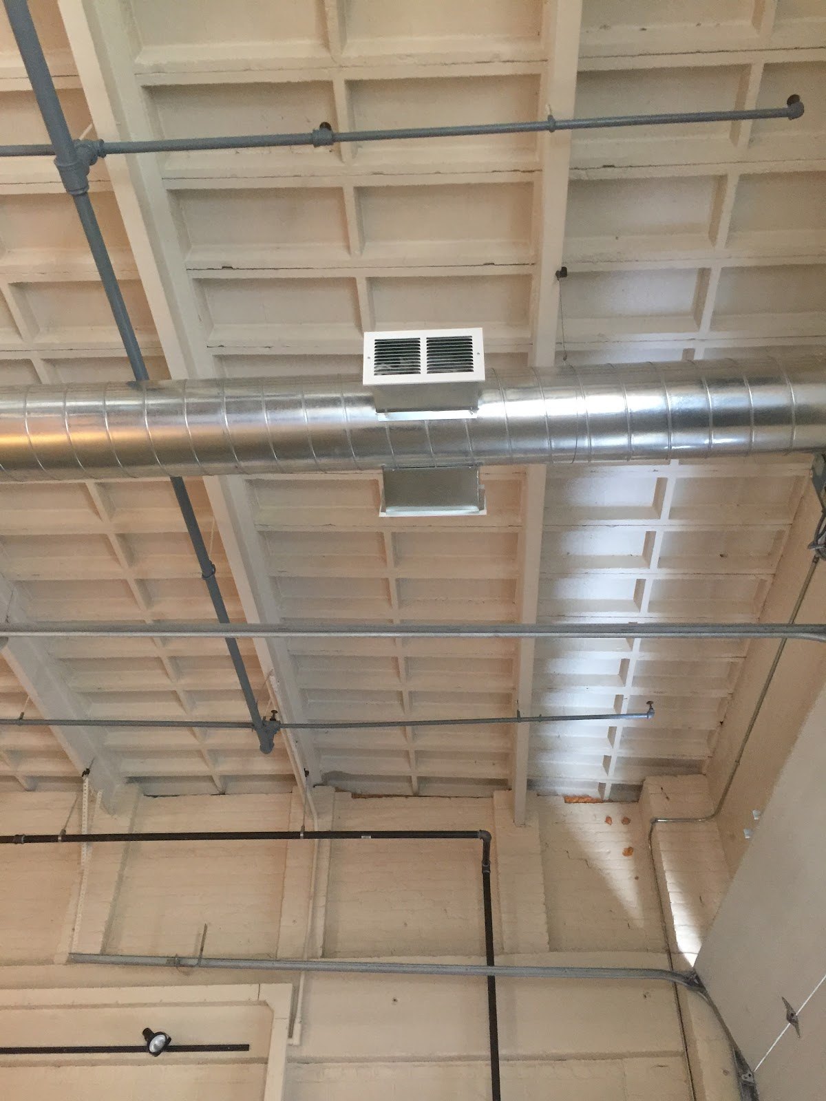 Spiral supply duct and register run through a commercial ceiling by Sam's HVAC in Worcester