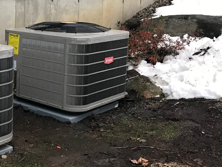 Bryant condenser installed on a pad beside a Worcester home by Sam's HVAC